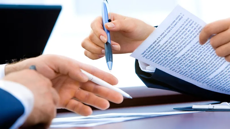 A team reviewing confidential financial documents and contracts together in a meeting